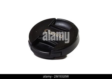 Delhi, India - Black lens cap isolated on white background. Canon logo on camera accessory Stock Photo