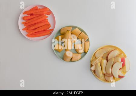 carrot, apple and banana slices on the plates, fresh vegetables and fruits Stock Photo