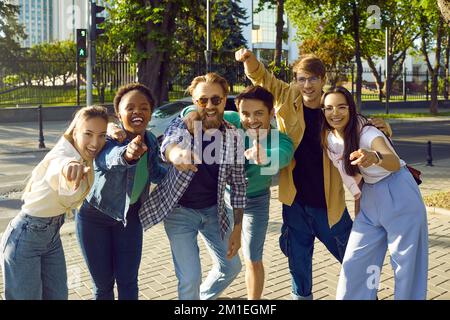 Group of happy young diverse people on city street smiling and pointing fingers at you Stock Photo
