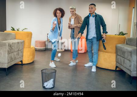 Multi-ethnic group of corporate employees getting rid of wastepaper Stock Photo