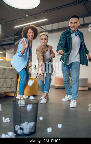 Three office employees getting rid of trash Stock Photo