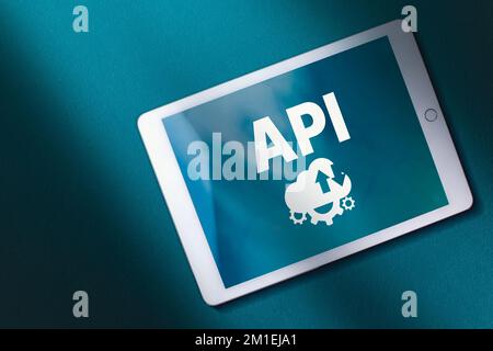 Top view of digital tablet with API acronym word on screen and teal background. Copy space. Internet and technology concept. Business, programming. Stock Photo