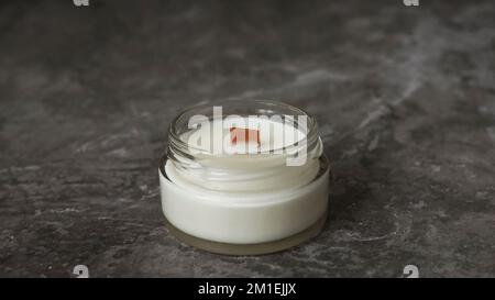 Label mockup of the glass jar with handmade candle with a wooden wick. Cozy home interior on a marble background Stock Photo