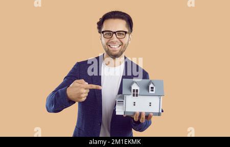 Smiling bearded young man real estate agent in a white T-shirt and blue jacket Stock Photo