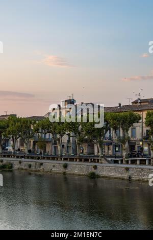 Buildings along the Allée Frédéric Mistral in Sommières, on the banks of the Vidourle River, at sunset Stock Photo