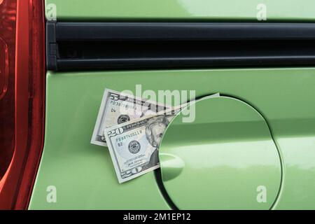 Banknotes in a gas tank from a car. A rise in fuel prices Stock Photo