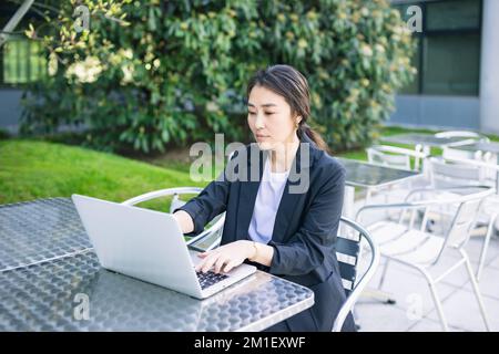 Asian confident business woman working with laptop outdoor, focused. Job, work concept. Business people lifestyle, copy space Stock Photo
