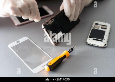 The technician repairing the smartphone's motherboard in the lab with copy space. the concept of computer hardware, mobile phone, electronic Stock Photo
