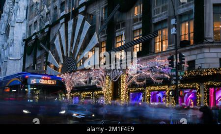 NEW YORK, NY, USA - DECEMBER 10, 2022: View from busy 5th avenue near decorated Saks store Stock Photo