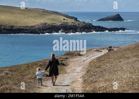 A mother and a toddler walking along the coast path on Pentire Point East in Newquay in Cornwall in the UK. Stock Photo