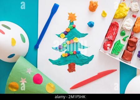 Making handmade Christmas cards. Childrens DIY concept. Little girl doing Christmas tree decoration or greeting cards from plasticine. Crafts for Stock Photo