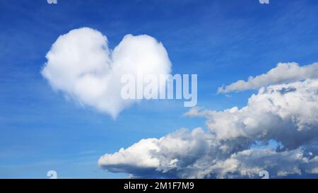 clouds on a blue sky with one cloud in the shape of a heart. horizontal frame. High quality photo Stock Photo