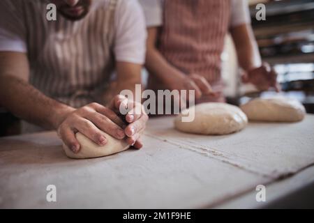 Close-up of bakers preparing fresh pastries in bakery. Stock Photo