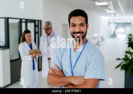 Portrait of young multiracial doctor standing at hospital corridor. Stock Photo