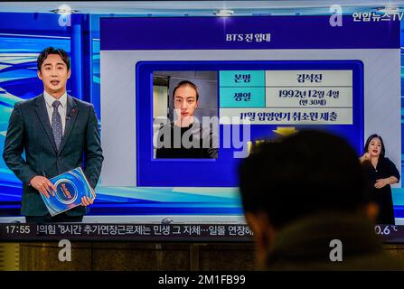 Jin, a member of K-pop group BTS, is showing a picture of his haircut and news of his enlistment in the South Korean army ahead of his enlistment in the military on TV at Yongsan Railway Station in Seoul. Jin, the member of the K-pop group BTS to serve in the military, has released a photo of himself with a military haircut ahead of his enlistment. The 30-year-old vocalist will enter a boot camp of a front-line Army 5 division in Yeoncheon, 60 kilometers north of Seoul, on 13 December, according to military and industry sources. After undergoing a five-week basic training program, Jin will be Stock Photo