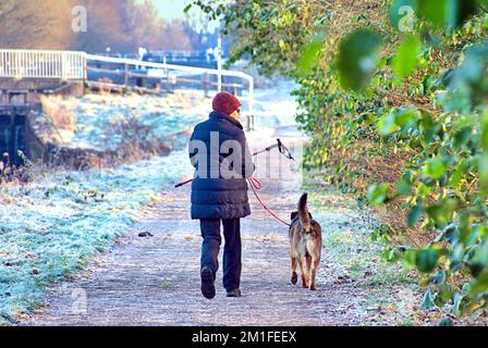 Glasgow, Scotland, UK 13th December, 2022. UK Weather: dog walker  Freezing temperatures saw a Cold night give rise to  frozen forth and clyde canal and freat western road  in knightswood in the north of the city.  Credit Gerard Ferry/Alamy Live News Stock Photo