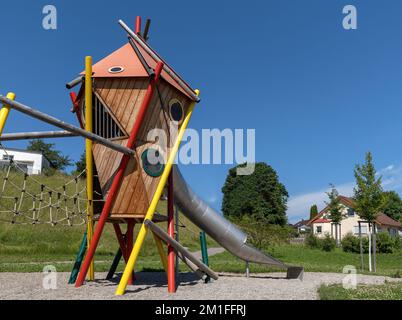 Modern colorful play tower with tunnel slide on a public playground Stock Photo