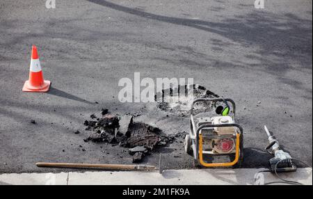 gasoline generator with tools for construction work on roads and urban roads, hammer drill in asphalt on site Stock Photo