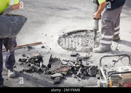 two workers in uniform work on the road Stock Photo