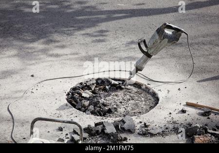 hammer drill in asphalt on site gasoline generator with tools construction work highways and urban roads Stock Photo