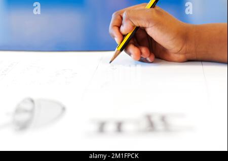 Close up of school pupil hand writing with a pencil Stock Photo