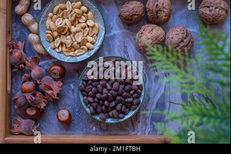A variety of nuts in bowls from top view. Walnuts, hazelnut, peanut and pine nuts, mix selection. Healthy fitness super food Stock Photo