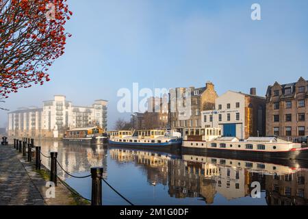 Barges or houseboats reflected in The Shore on the Water of Leith river, Leith, Edinburgh, Scotland, UK Stock Photo