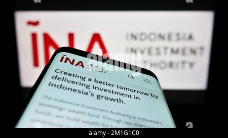 Mobile phone with webpage of Indonesia Investment Authority (INA) on screen in front of business logo. Focus on top-left of phone display. Stock Photo