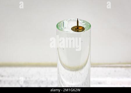 A metal pin floats on water due to the surface tension caused by the cohesion of water molecules. Science experiment in physics class. Stock Photo