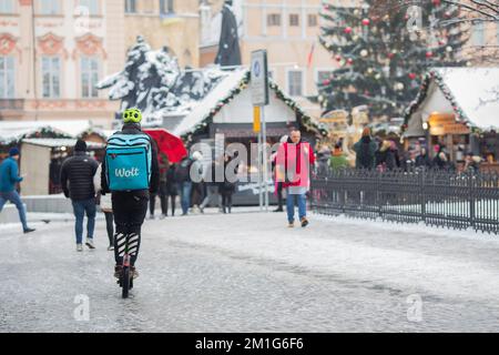 PRAGUE, Czech Republic – DECEMBER 12th 2022: Wolt worker courier on a scooter in snow - Christmas time at old square Stock Photo