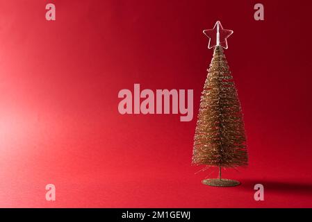 Small decorative christmas tree on red background. Stock Photo