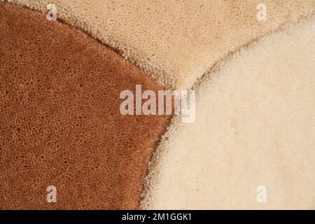 Motley carpet background texture, with thick pile abstract pattern. Close up of beige, white and brown rug, fleece fabric texture, fragment for backdrop. Concept of textures and backgrounds. Stock Photo