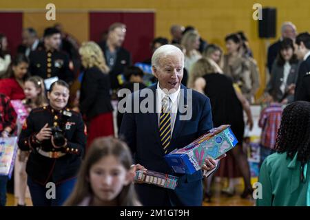 Arlington, United States. 12th Dec, 2022. US President Joe Biden carries toys while participating in a United States Marine Corps Reserve Toys for Tots event at Joint Base Myer-Henderson Hall in Arlington, Virginia, on Monday, December 12, 2022. The Biden's are joining spouses of senior Department of Defense and Service Leadership and local military children in sorting donated toys for distribution to families in need ahead of the holidays. Photo by Al Drago/UPI Credit: UPI/Alamy Live News Stock Photo