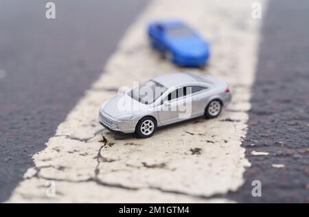 Incidents. Two cars are moving along a solid road marking line. One of the cars is out of focus. Stock Photo