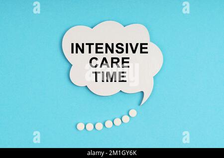 Medicine and health concept. On a blue table are pills and a white plate with the inscription - Intensive care time Stock Photo