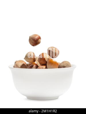 Hazelnuts in a white cup on a white isolated background Stock Photo