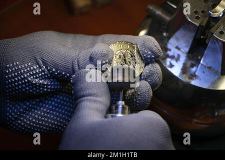 Close-up of engravers hands engraving on gold watch blank, handmade watch production order, watch custom order, selective focus Stock Photo