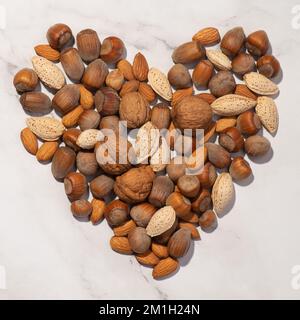 Heart made of nuts on a gray background Stock Photo