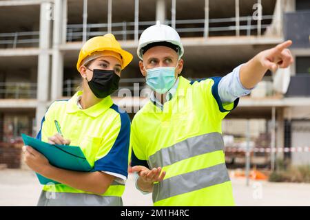Civil engineers in masks checking work process Stock Photo