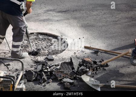 jackhammer in hands of asphalt worker logging Stock Photo