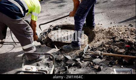 two workers in uniform work on the road Stock Photo