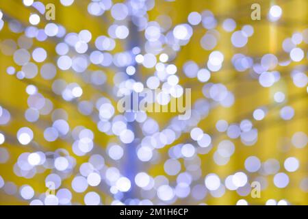 out of focus christmas lights, yellow background blue tint Stock Photo