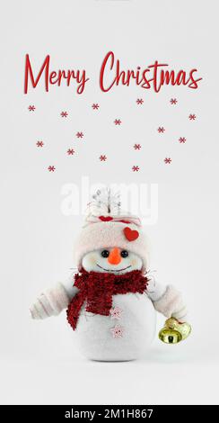 Handmade Cute snowman holding jingle bells on vertical white background Stock Photo