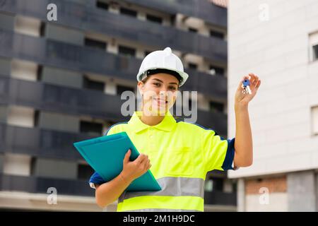 Portrait of a young smiling woman working as a process engineer, demonstrating the keys Stock Photo