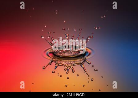 A splash of a drop in the form of a crown in the bright colors of the rainbow Stock Photo