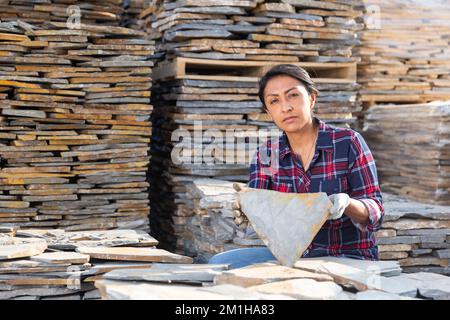Hispanic woman worker posing with natural stone tile Stock Photo