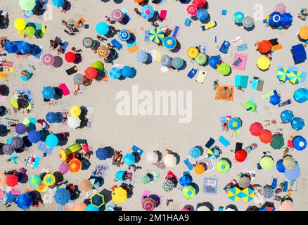 Aerial view of colorful umbrellas on sandy beach and people Stock Photo