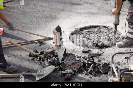 two workers in uniform work on the road Stock Photo