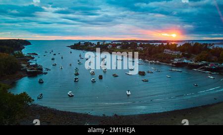 Maine bay at sunset filled with ships and boats and golden glow of sun Stock Photo