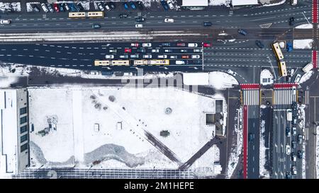 11.21.2022 Warsaw, Poland. High-angle top view of one the main streets in Warsaw and building rooftop covered with snow. Drone aerial perspective. High quality photo Stock Photo